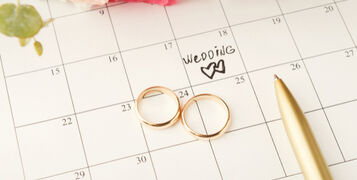 Word,Wedding,,Two,Hearts,And,Gold,Rings,On,Calendar,With